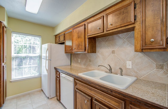 kitchen with sink, white appliances, decorative backsplash, and light tile patterned flooring