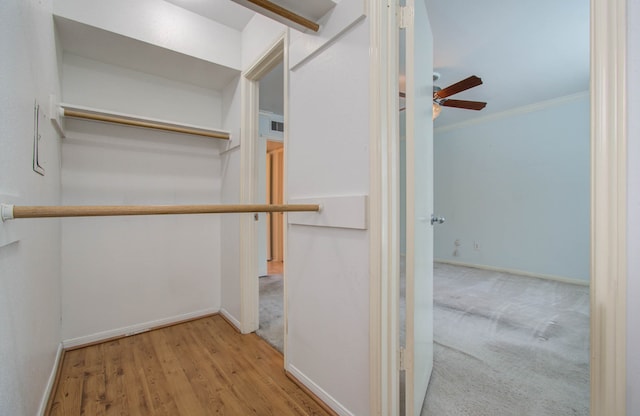 spacious closet featuring ceiling fan and light hardwood / wood-style floors