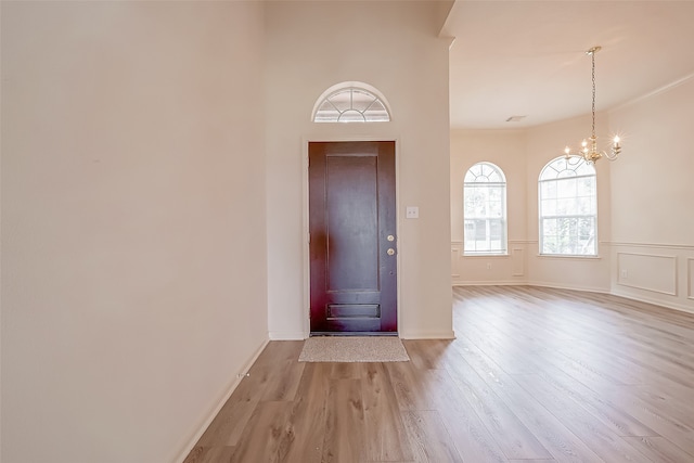 entrance foyer with light hardwood / wood-style flooring and a notable chandelier