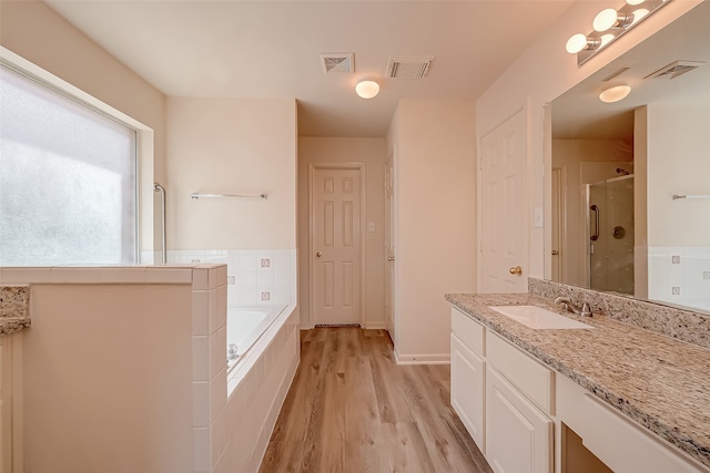 bathroom with vanity, hardwood / wood-style flooring, and separate shower and tub