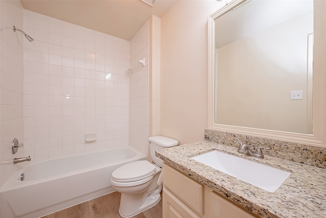 full bathroom with vanity, toilet, wood-type flooring, and tiled shower / bath