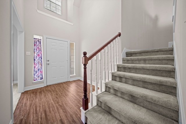 foyer entrance with hardwood / wood-style floors and a high ceiling