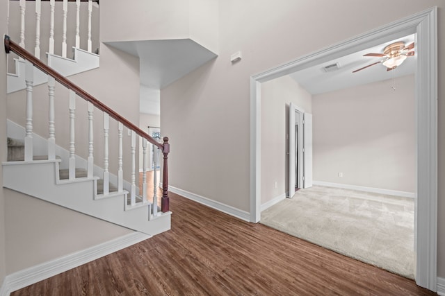 stairway featuring ceiling fan and hardwood / wood-style floors