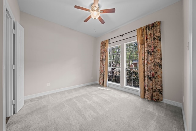 spare room featuring light carpet and ceiling fan