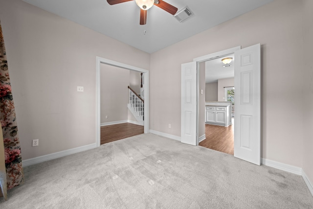 carpeted spare room featuring ceiling fan