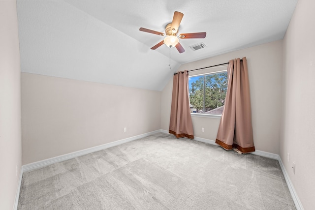 additional living space featuring light colored carpet, vaulted ceiling, and ceiling fan