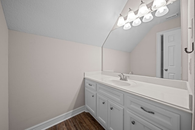 bathroom with vanity, wood-type flooring, and vaulted ceiling