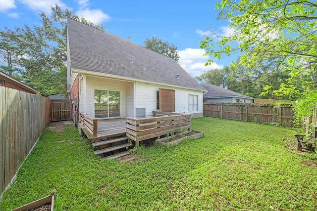 rear view of property with a deck and a yard