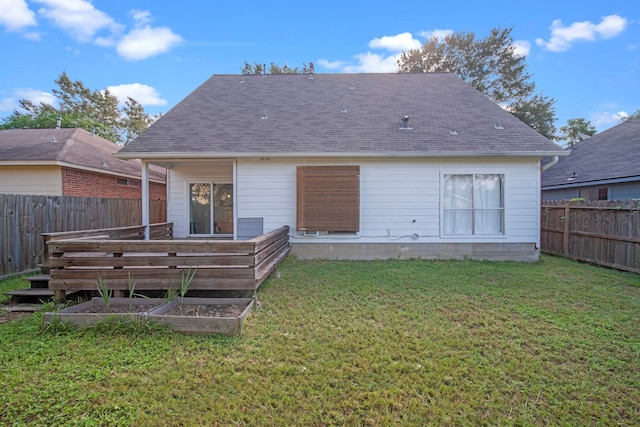 rear view of property with a lawn and a wooden deck