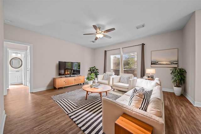 living room with light hardwood / wood-style flooring and ceiling fan