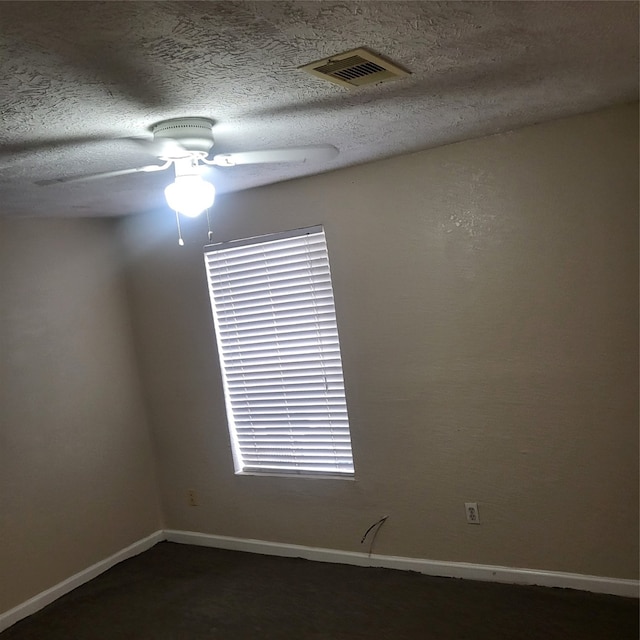 empty room with a textured ceiling and ceiling fan