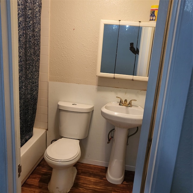 bathroom with toilet, hardwood / wood-style floors, and shower / bath combo with shower curtain