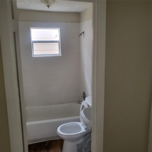 bathroom featuring shower / tub combination and toilet