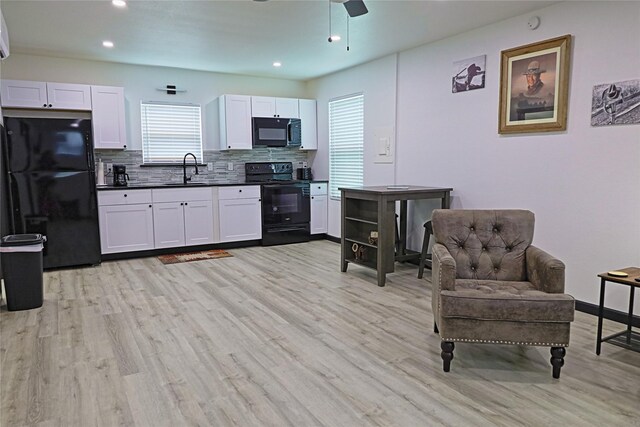 kitchen featuring black appliances, light hardwood / wood-style flooring, decorative backsplash, ceiling fan, and white cabinets