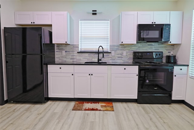 kitchen featuring black appliances, sink, light wood-type flooring, and white cabinetry