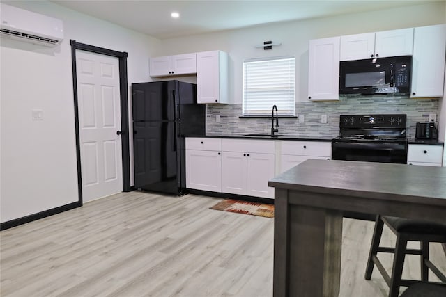 kitchen featuring black appliances, sink, white cabinets, and a wall mounted air conditioner