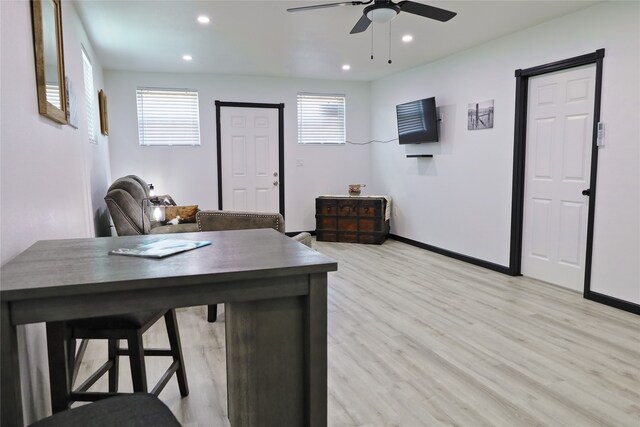 home office with plenty of natural light, ceiling fan, and light hardwood / wood-style flooring