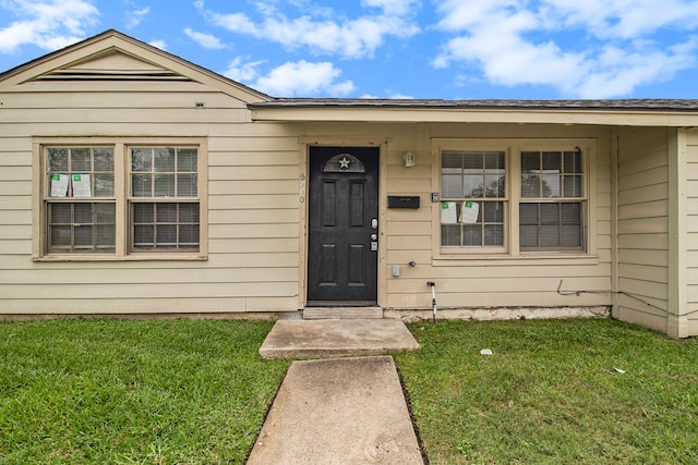 entrance to property with a lawn