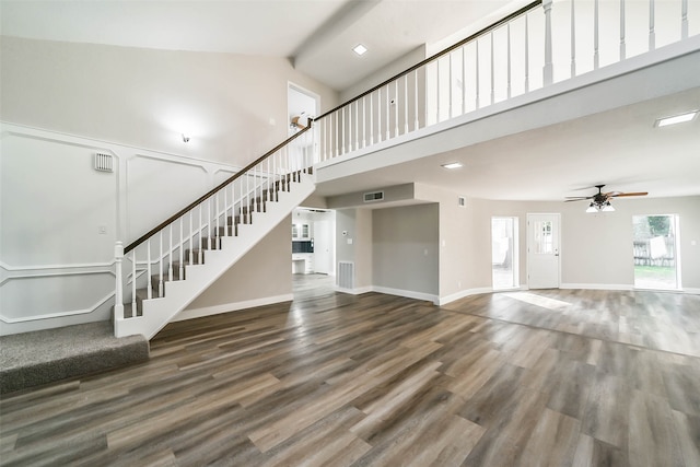 unfurnished living room featuring dark wood-type flooring, high vaulted ceiling, and ceiling fan