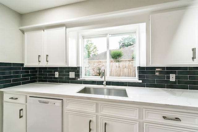 kitchen with white dishwasher, sink, and white cabinets