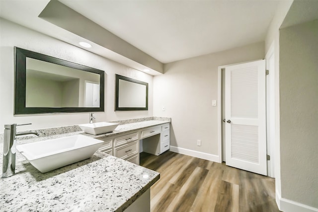 bathroom with a bath, hardwood / wood-style floors, and vanity