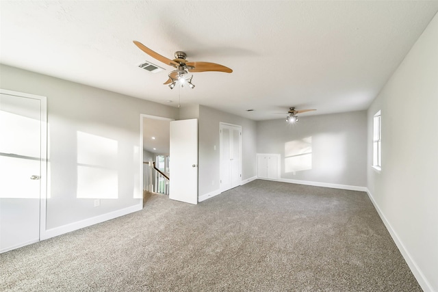 carpeted empty room featuring ceiling fan