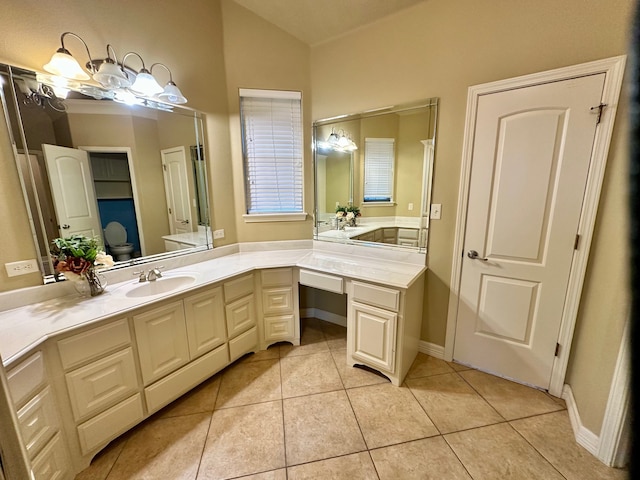 bathroom with vanity, toilet, tile patterned flooring, and lofted ceiling