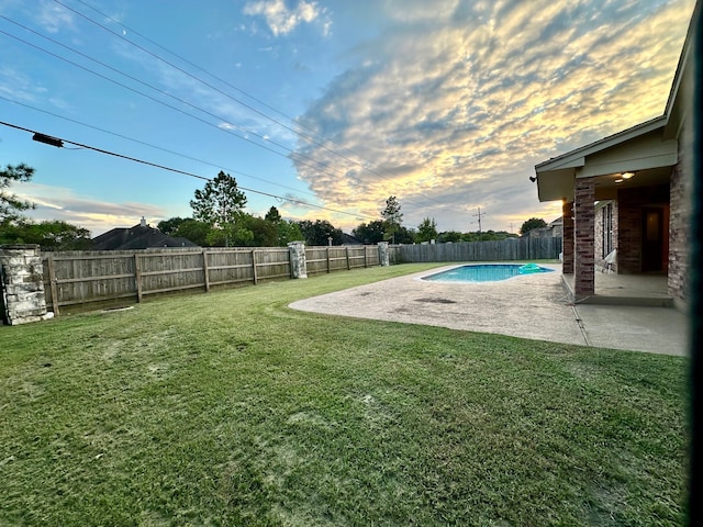 yard at dusk featuring a fenced in pool and a patio