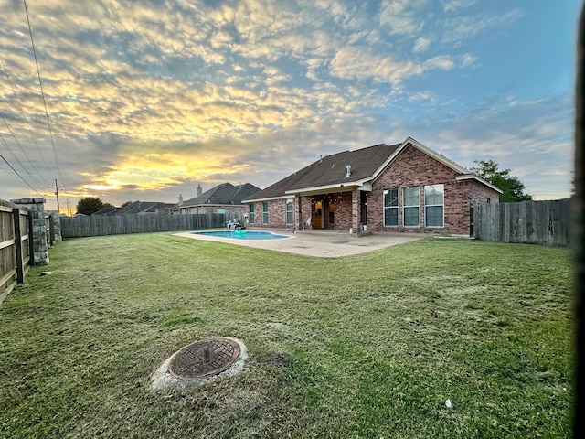 yard at dusk featuring a patio