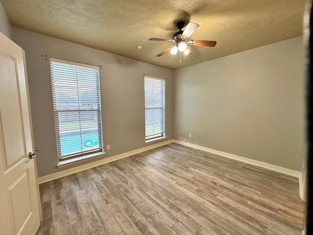 unfurnished room featuring a textured ceiling, ceiling fan, and hardwood / wood-style flooring