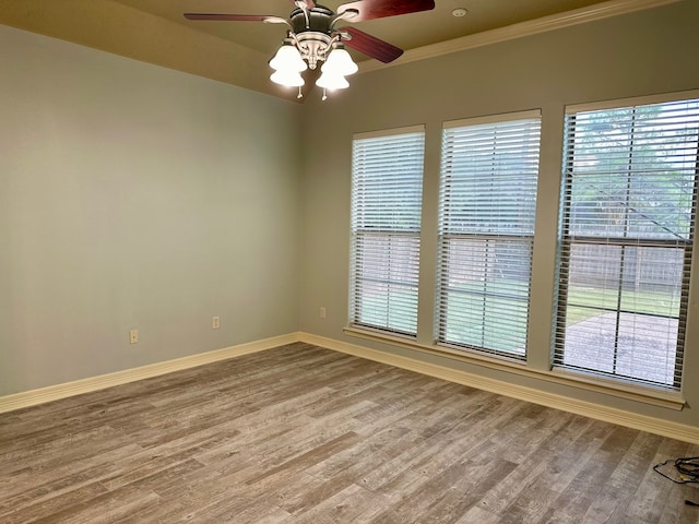 empty room featuring ceiling fan, hardwood / wood-style flooring, and ornamental molding