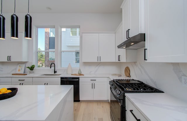 kitchen featuring black appliances, light stone counters, white cabinetry, and sink