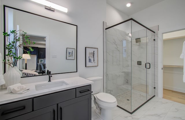 bathroom featuring vanity, toilet, and a shower with shower door