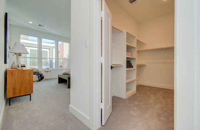 walk in closet featuring light carpet