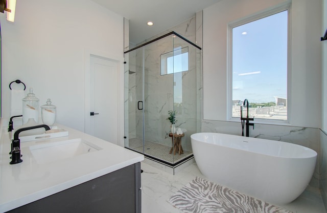 bathroom with vanity, tile walls, and separate shower and tub