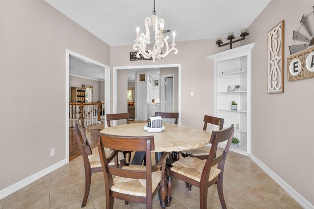 dining room with built in shelves, light tile patterned flooring, and an inviting chandelier