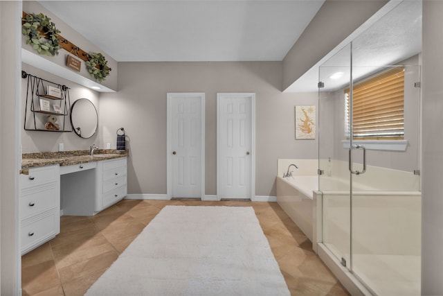 bathroom with a shower stall, baseboards, vanity, and a garden tub