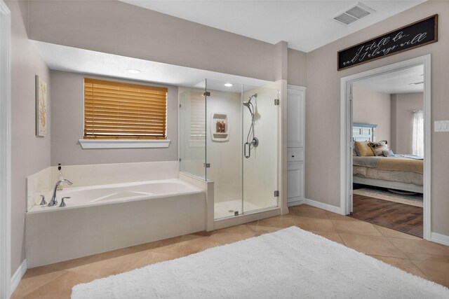 bathroom featuring tile patterned flooring and shower with separate bathtub