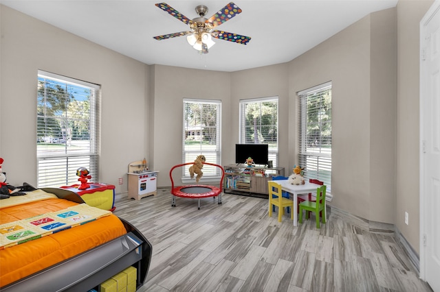 bedroom featuring multiple windows, light hardwood / wood-style floors, and ceiling fan