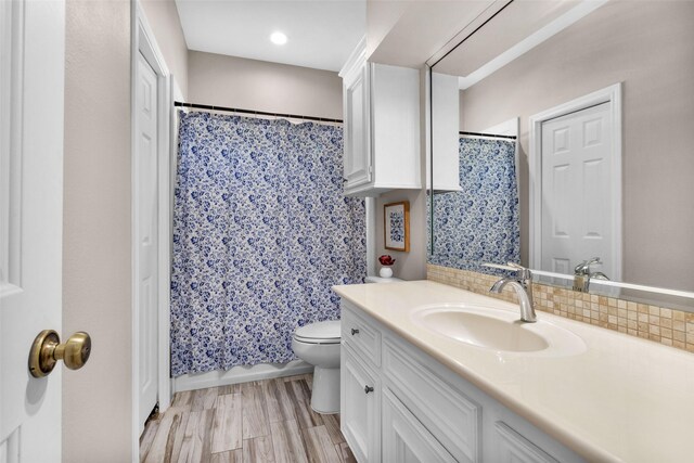 bathroom featuring vanity, toilet, walk in shower, tasteful backsplash, and wood-type flooring