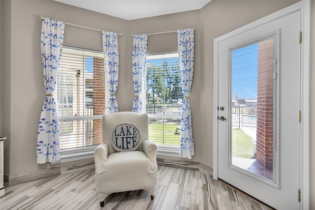 living area featuring a wealth of natural light and light hardwood / wood-style flooring