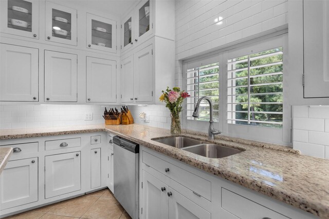 kitchen with dishwasher, backsplash, white cabinets, and sink