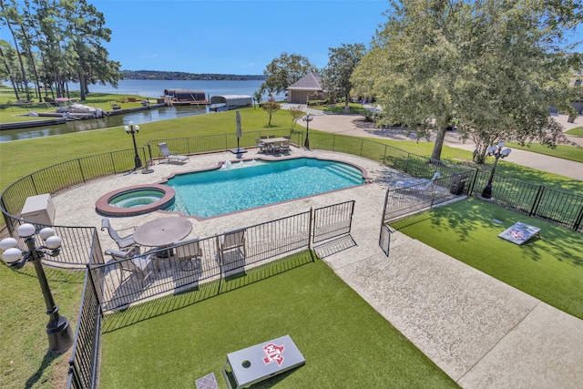 view of swimming pool with a lawn, a patio area, a community hot tub, and a water view