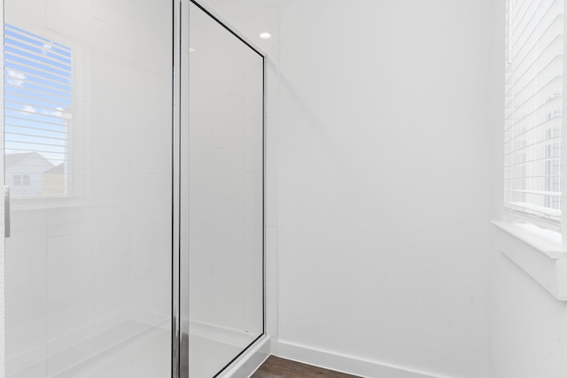 bathroom with wood-type flooring and walk in shower