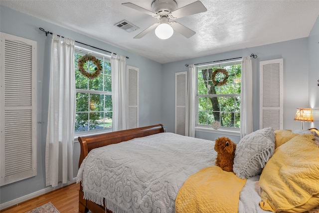 bedroom featuring ceiling fan, a textured ceiling, and light hardwood / wood-style flooring