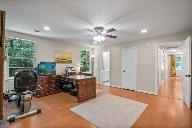 home office with ceiling fan, light hardwood / wood-style floors, and a healthy amount of sunlight