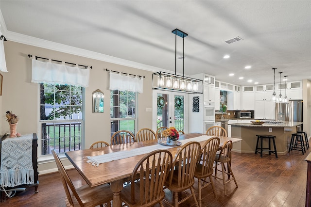 dining area featuring crown molding, a notable chandelier, and dark hardwood / wood-style flooring