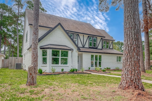 tudor-style house with a front lawn and cooling unit