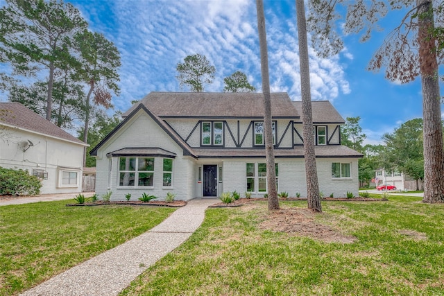 tudor home featuring a front lawn