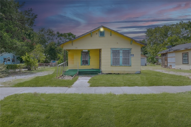 bungalow-style house with a lawn and a porch